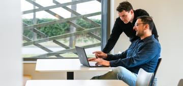 afbeelding personen die samen werken achter laptop