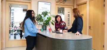 afbeelding personen die overleggen aan staantafel