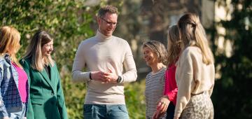 afbeelding mensen pratend buiten in een groep