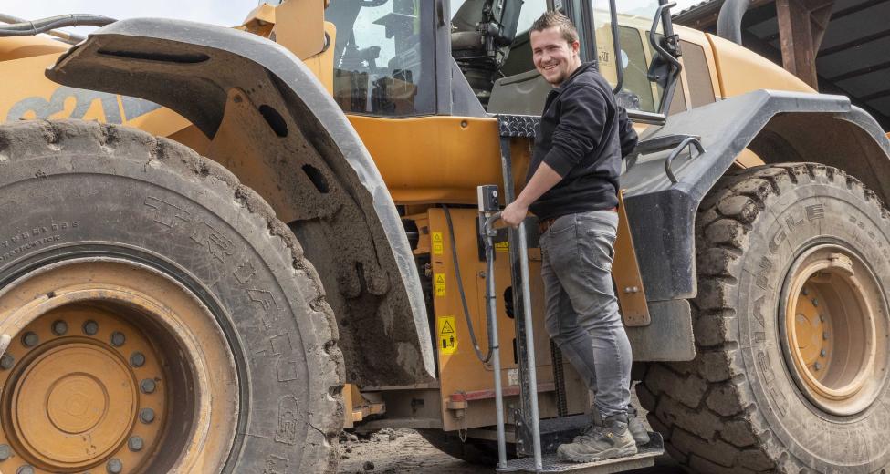 Afbeelding: man op lift van shovel