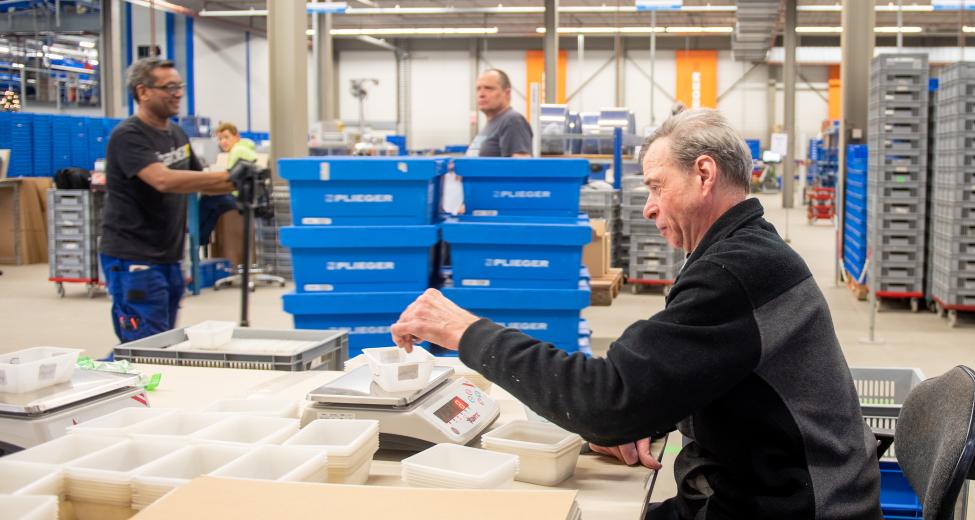 afbeelding man achter bureau in productieruimte