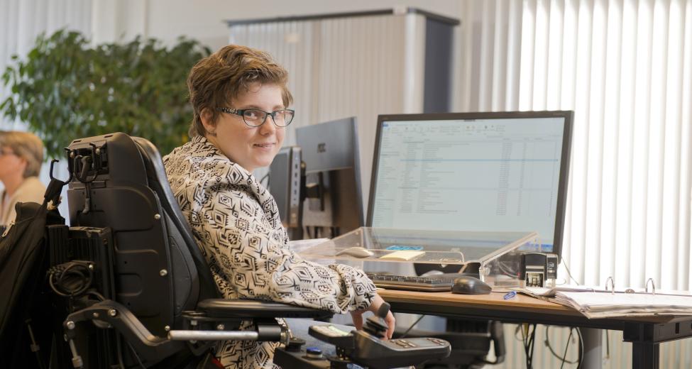 Afbeelding: vrouw in rolstoel achter computer