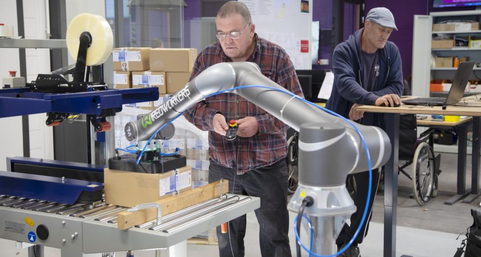 afbeelding Man werkt met robotarm