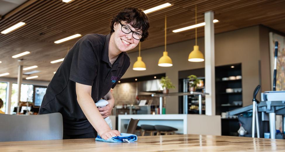 afbeelding vrouw maakt tafel schoon