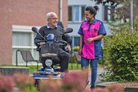 Afbeelding: Vrouw loopt naast man in rolstoel