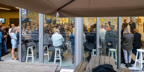 afbeelding: groepsbijeenkomst door raam gefotografeerd