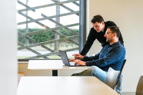 afbeelding personen die samen werken achter laptop