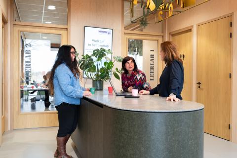 afbeelding personen die overleggen aan staantafel