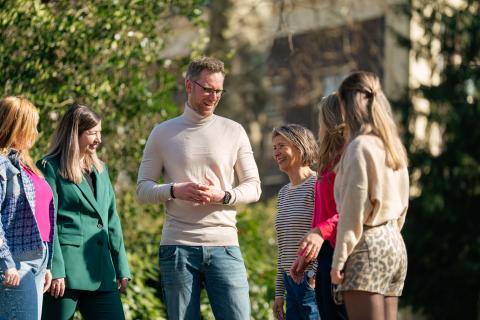 afbeelding mensen pratend buiten in een groep