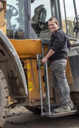 Afbeelding: man op lift van shovel