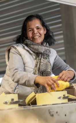 Afbeelding: vrouw aan werktafel pakt dozen in