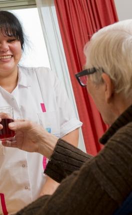 Afbeelding: vrouw geeft glas aan man