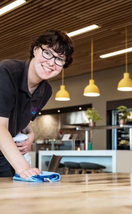 afbeelding vrouw maakt tafel schoon